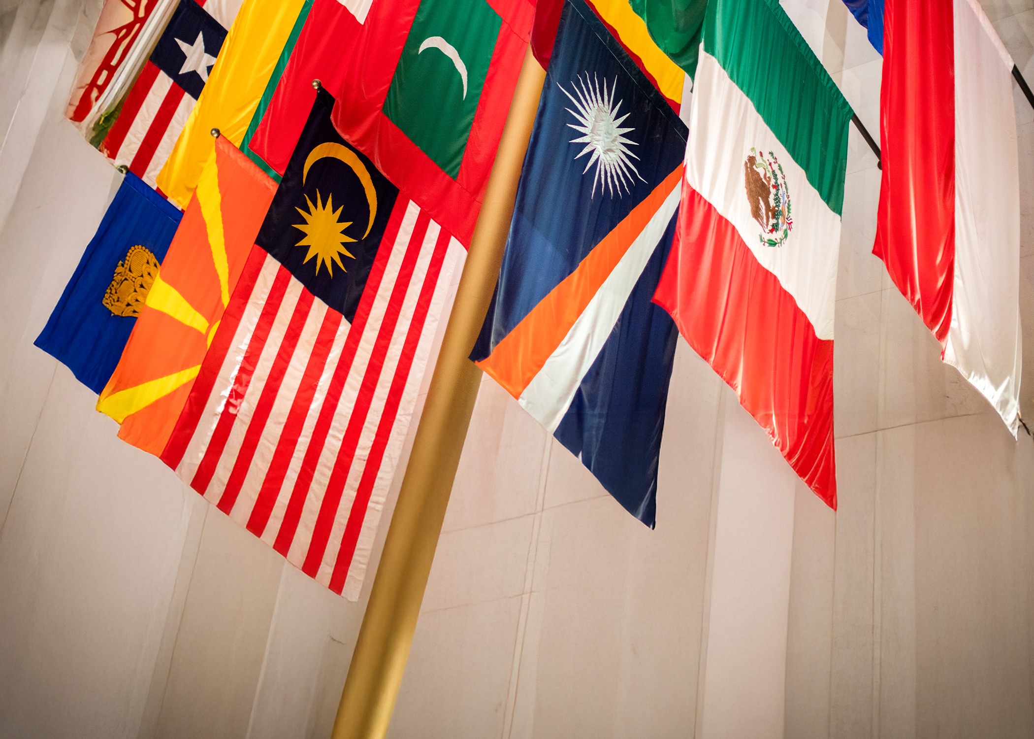 A row of international flags hanging from the ceiling at NYU's Center for Gloval Affairs