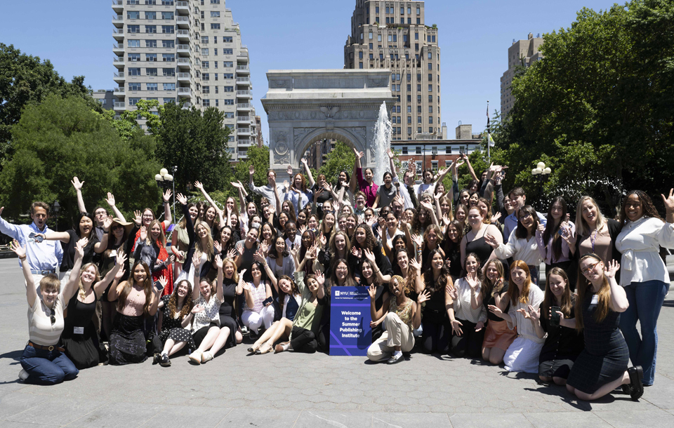 Students pose in front of the arch in Washington Sq Park