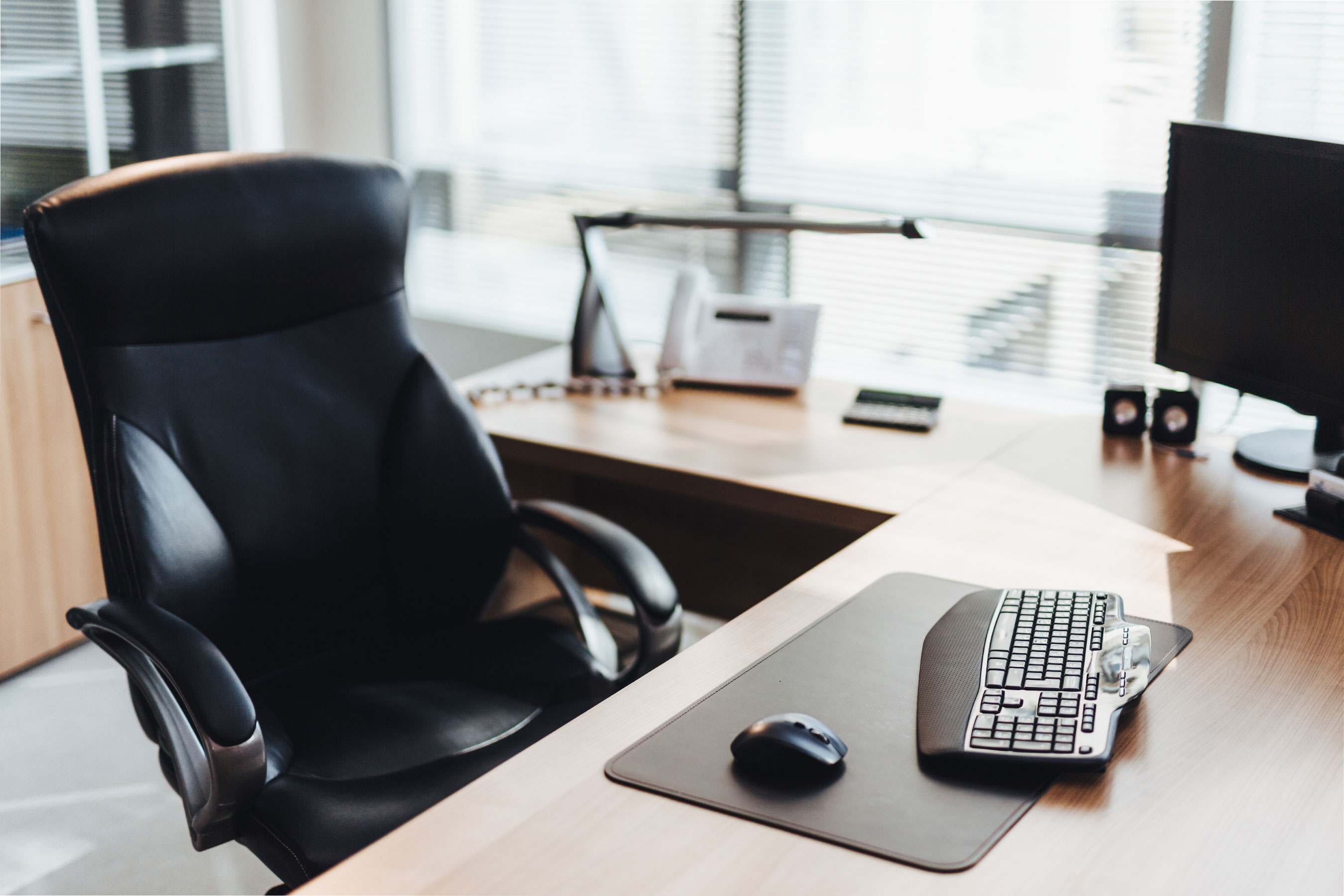 Empty chair at wooden desk in an office.