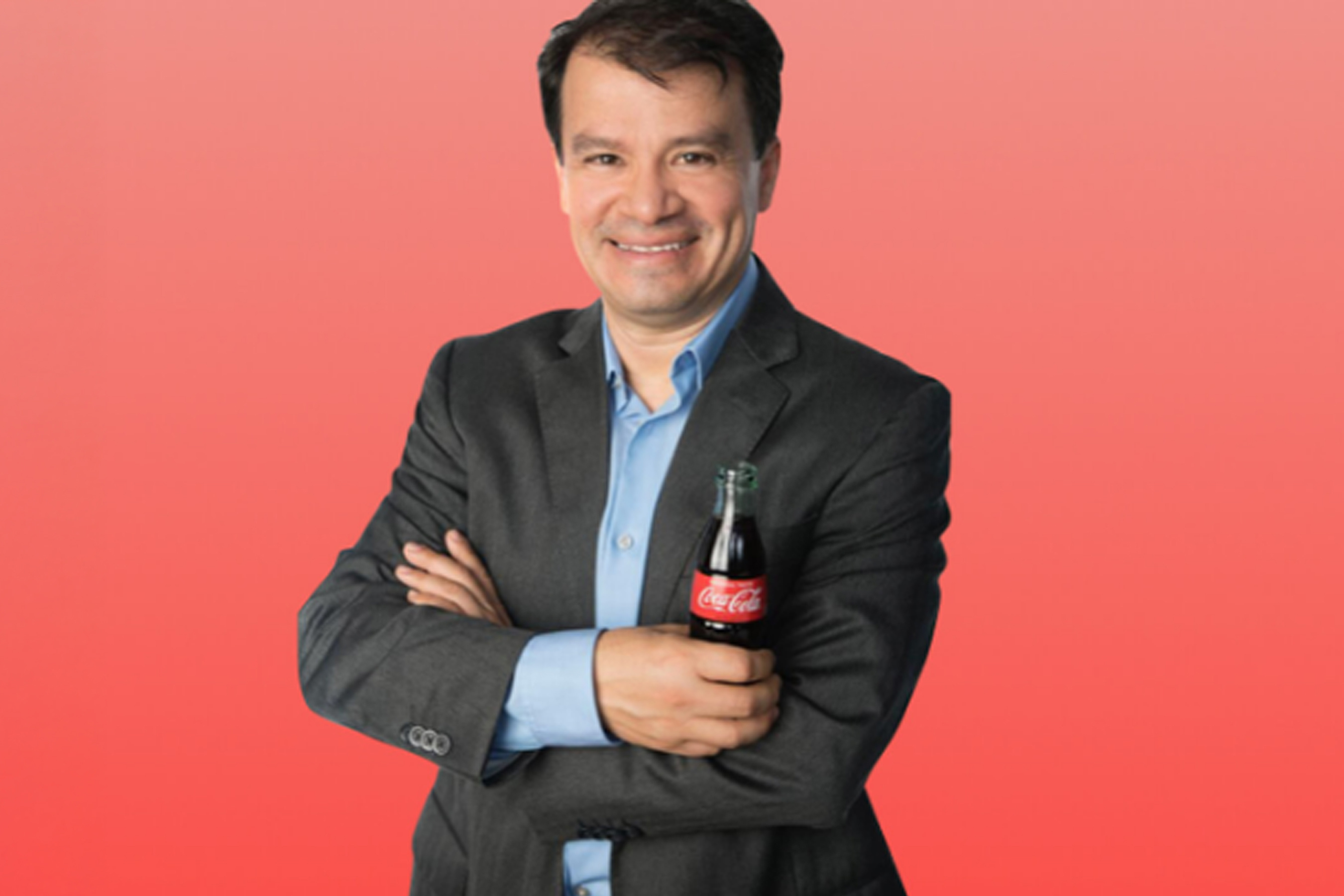Javier Meza holds a coke bottle and smiles