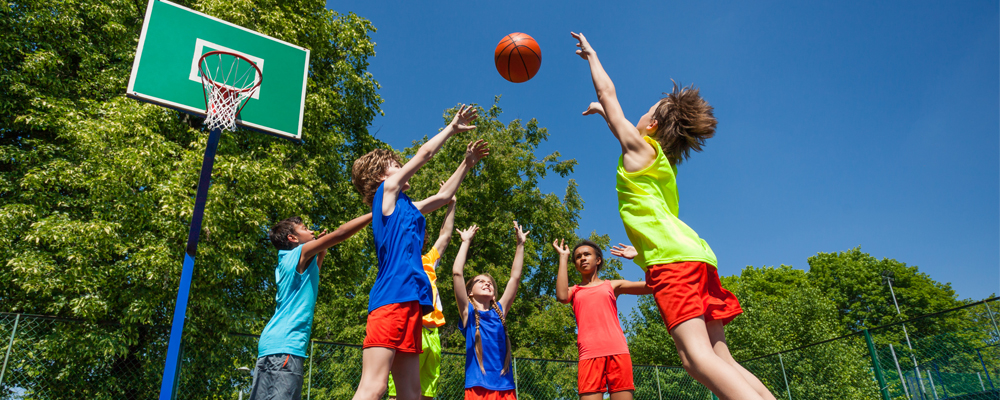 Young women jumping up for a basketball under basketball hoop