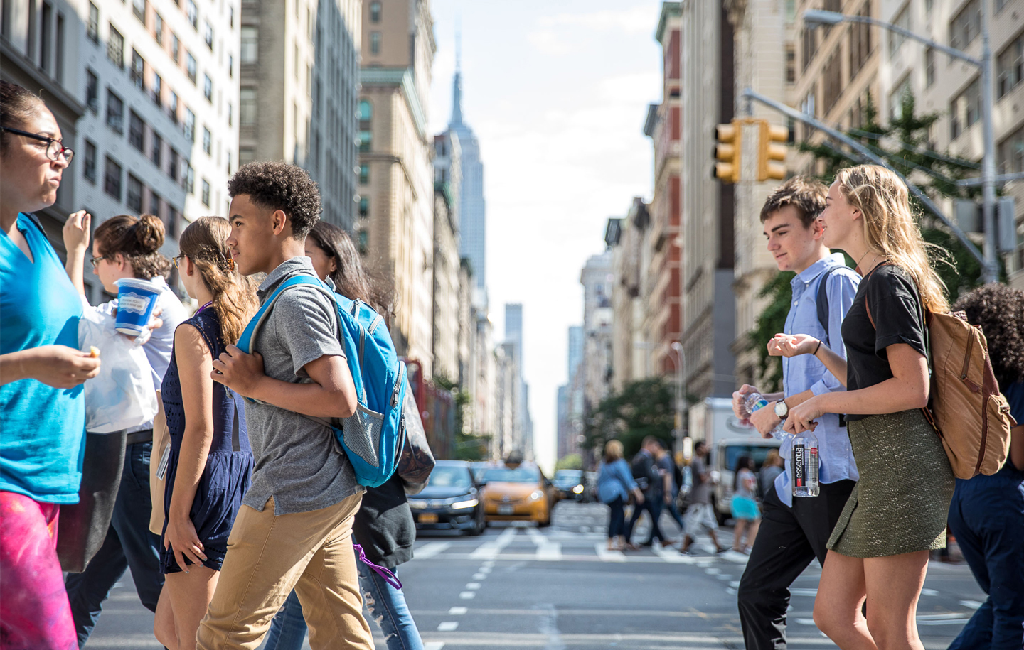 A group of students cross a street in NYC.