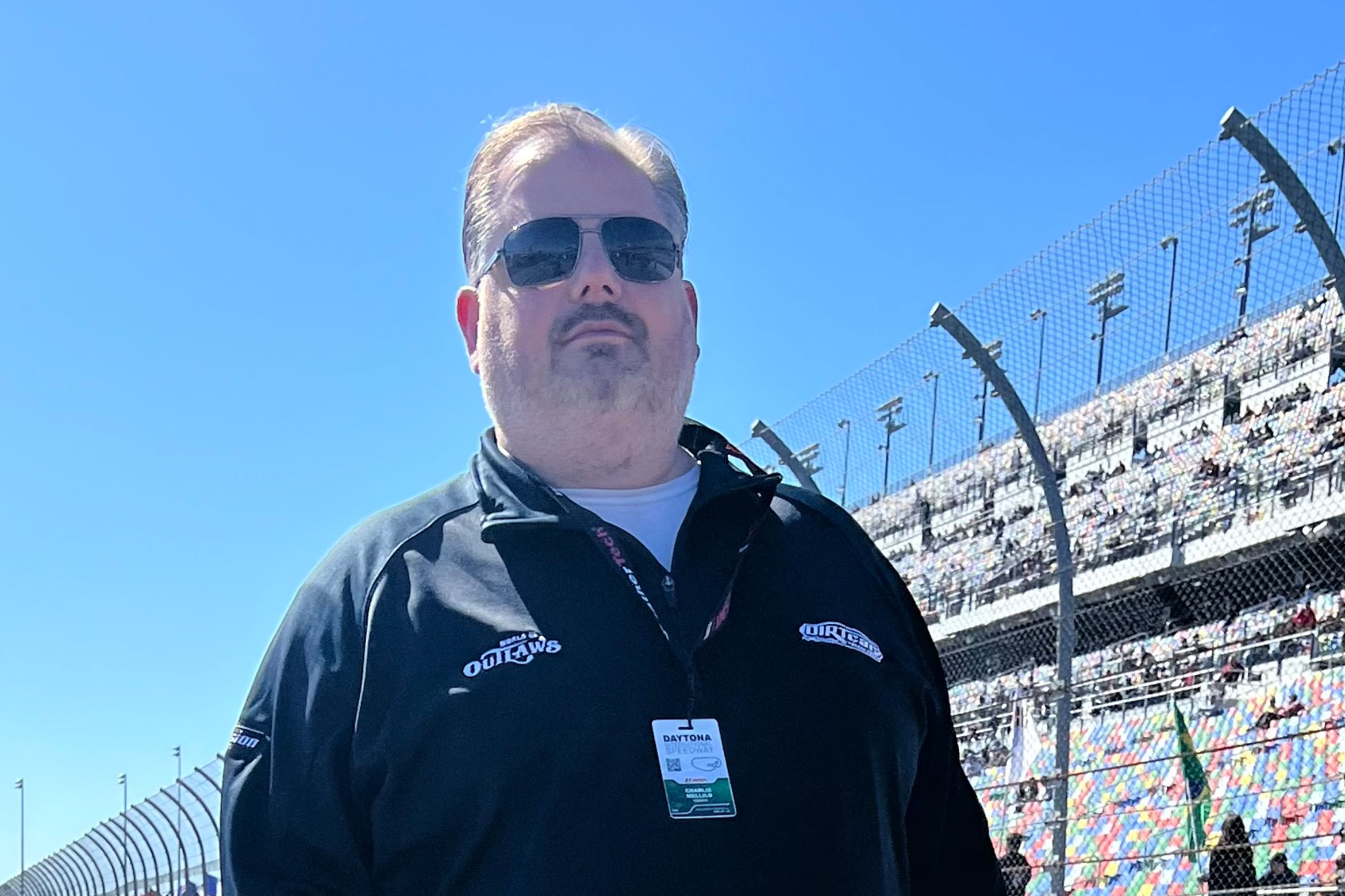 NYU SPS CE faculty member Charles Mellilo smiles for a photo at a race track